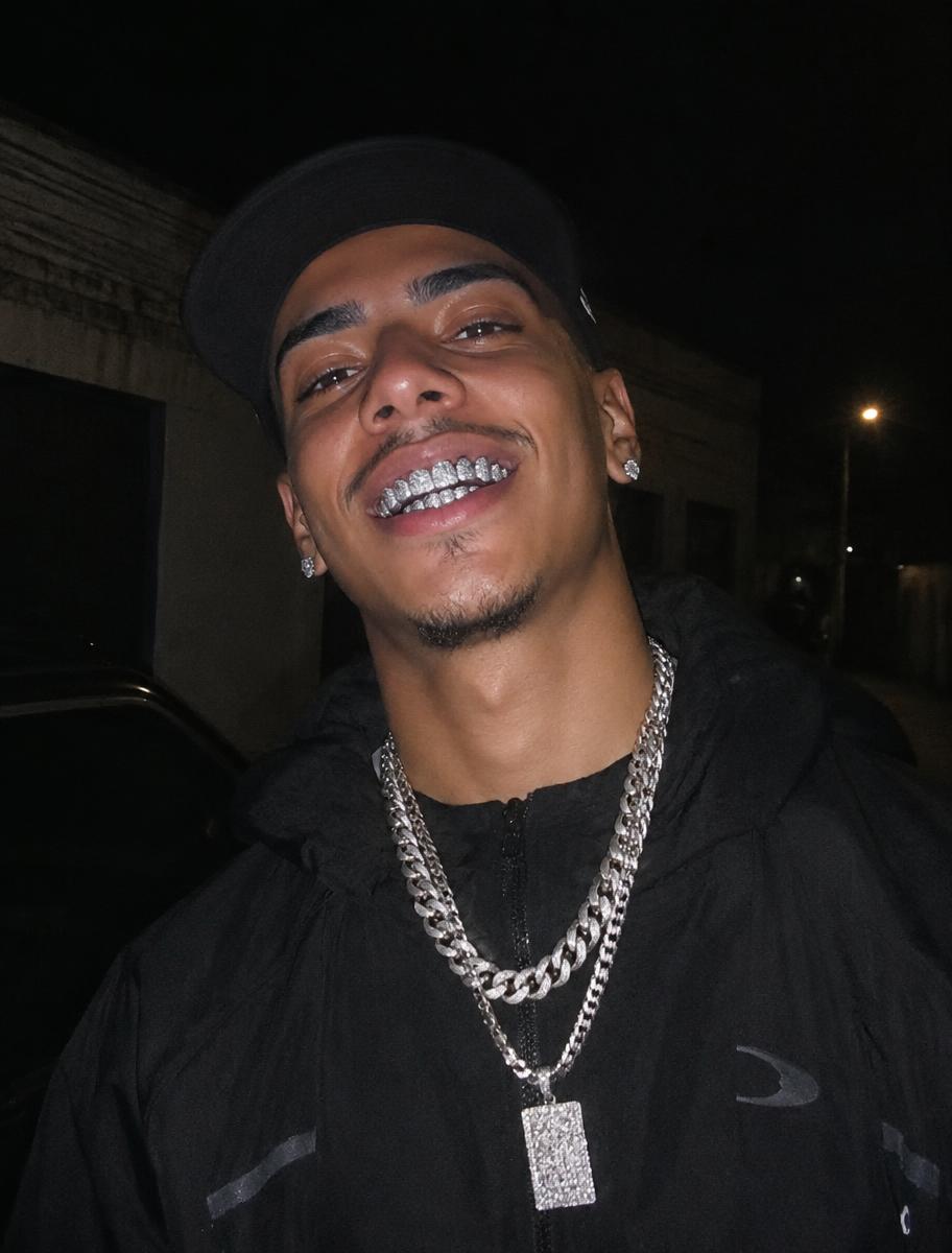 Cliente sorrindo com grillz em foto noturna com flash